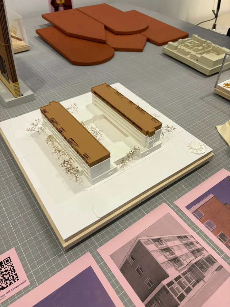 Twee maquettes op tafel, op geprinte tekeningen