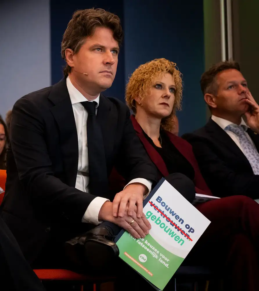 Drie sprekers naast elkaar tijdens een paneelgesprek