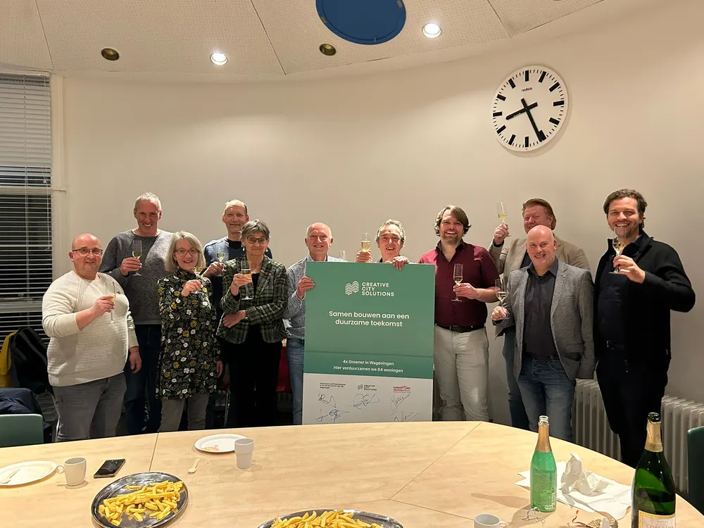 Een groep collega's bij elkaar achter een tafel